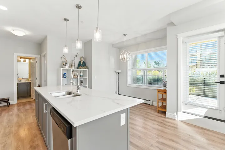 Condo kitchen with pendant lighting and a window looking out to neighboring high-rises