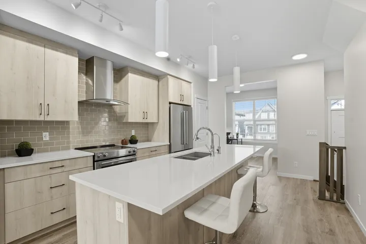 Bright kitchen with light wood cabinets and a quartz island